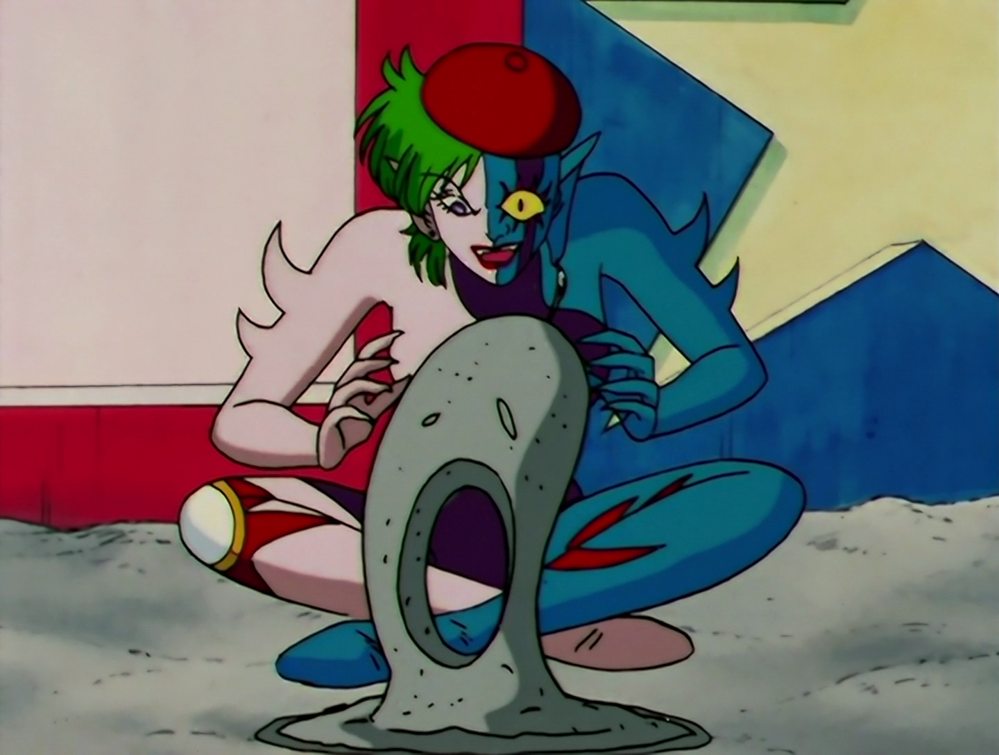 Chokokkar has now lost the jacket, revealing that the white, blue, purple and red pattern is spread over her whole body. She has spikes on her arms, and she’s sitting in a sandpit, manipulating the sand into a solid shape.